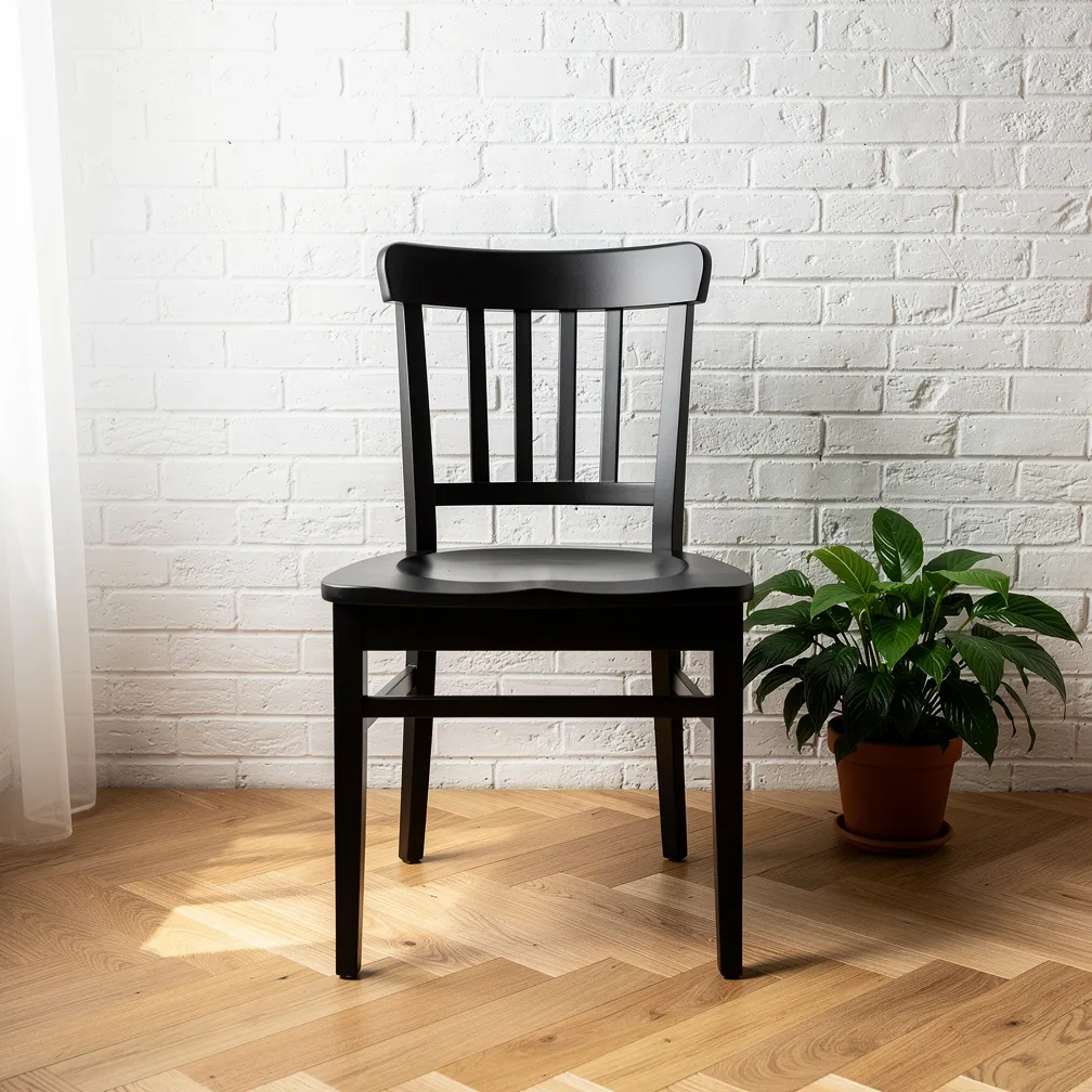 Chaise de cuisine en bois peinte en noir mat sur parquet chene clair a chevrons, mur en briques blanches