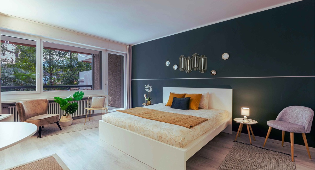 Chambre moderne avec mur vert sauge et décoration intérieure épurée