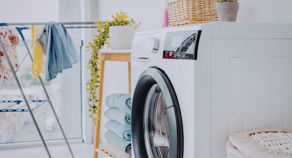 Buanderie moderne amenagee avec lave-linge et etendoir a linge