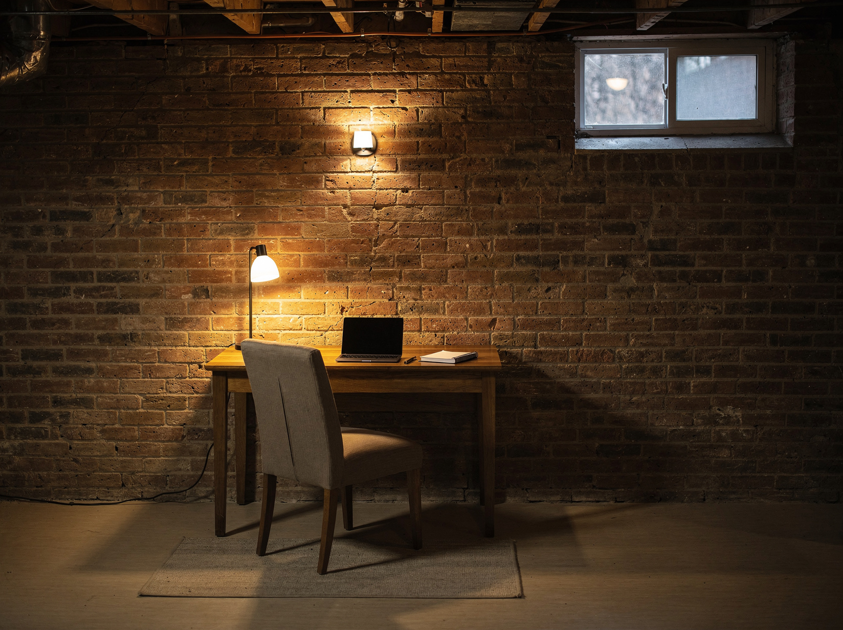 Cave aménagée en bureau avec mur de briques