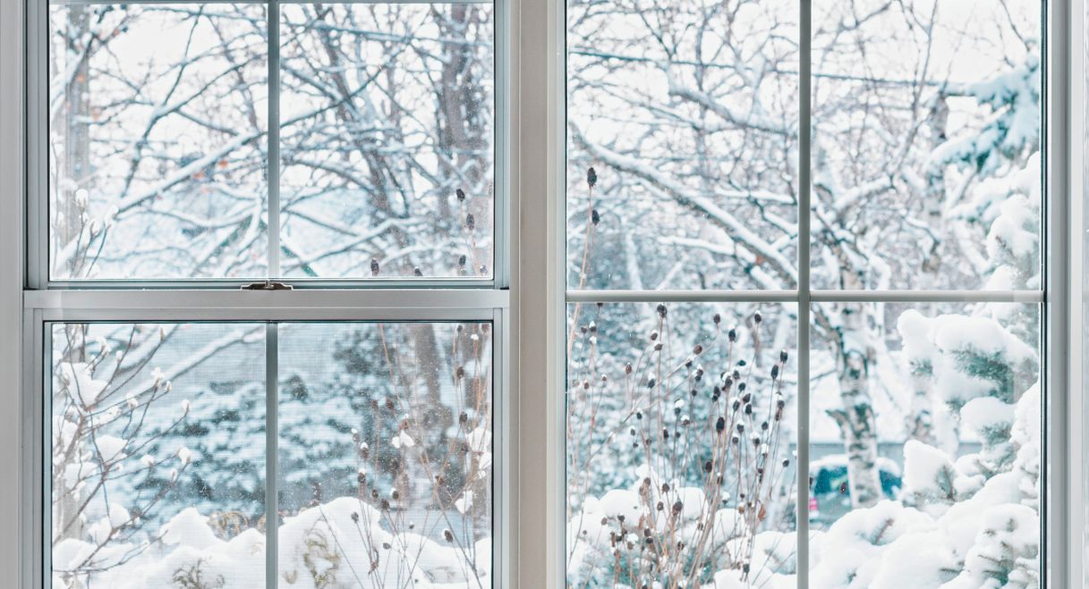 Fenêtre donnant sur un paysage hivernal enneigé par temps froid
