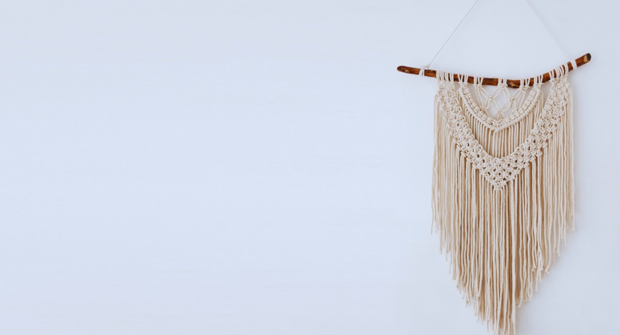 Suspension murale en macramé artisanal sur un mur blanc