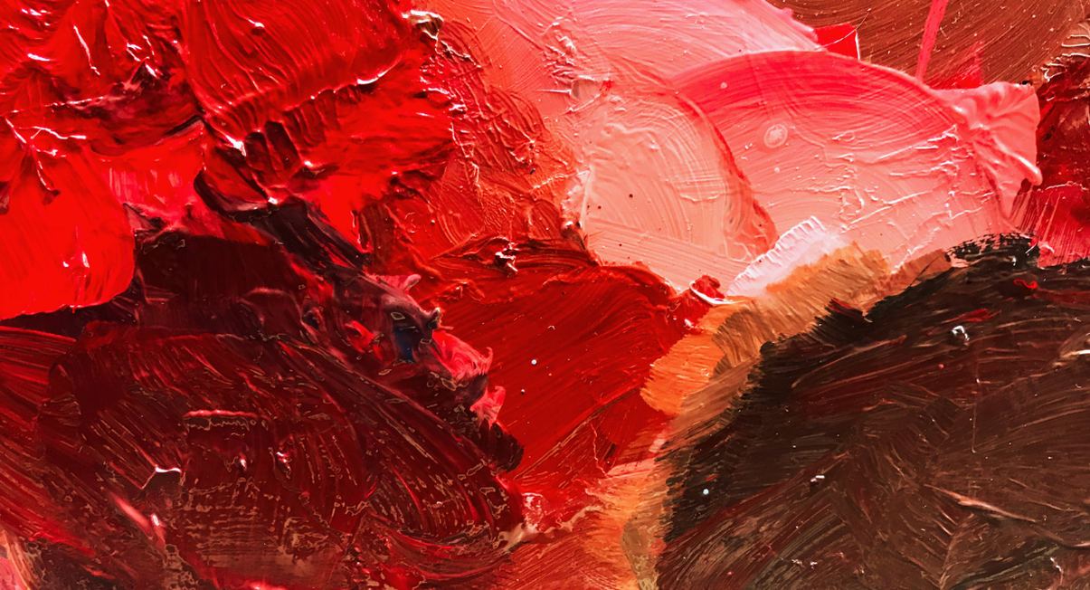 Gros plan sur de la peinture rouge mélangée avec des nuances sur une palette d'artiste