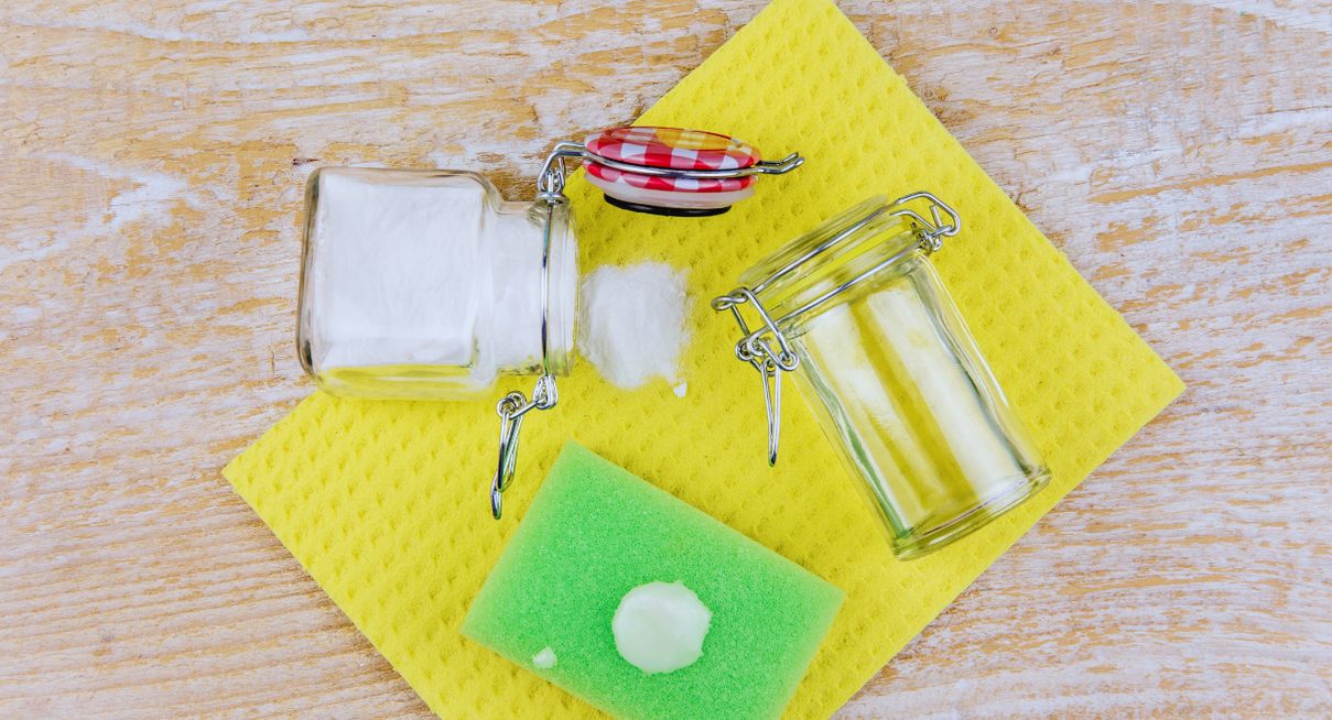 Bocaux de poudre nettoyante et eponge verte avec une noisette de pate blanche