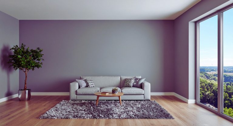 Salon épuré avec mur gris clair, canapé et grande fenêtre